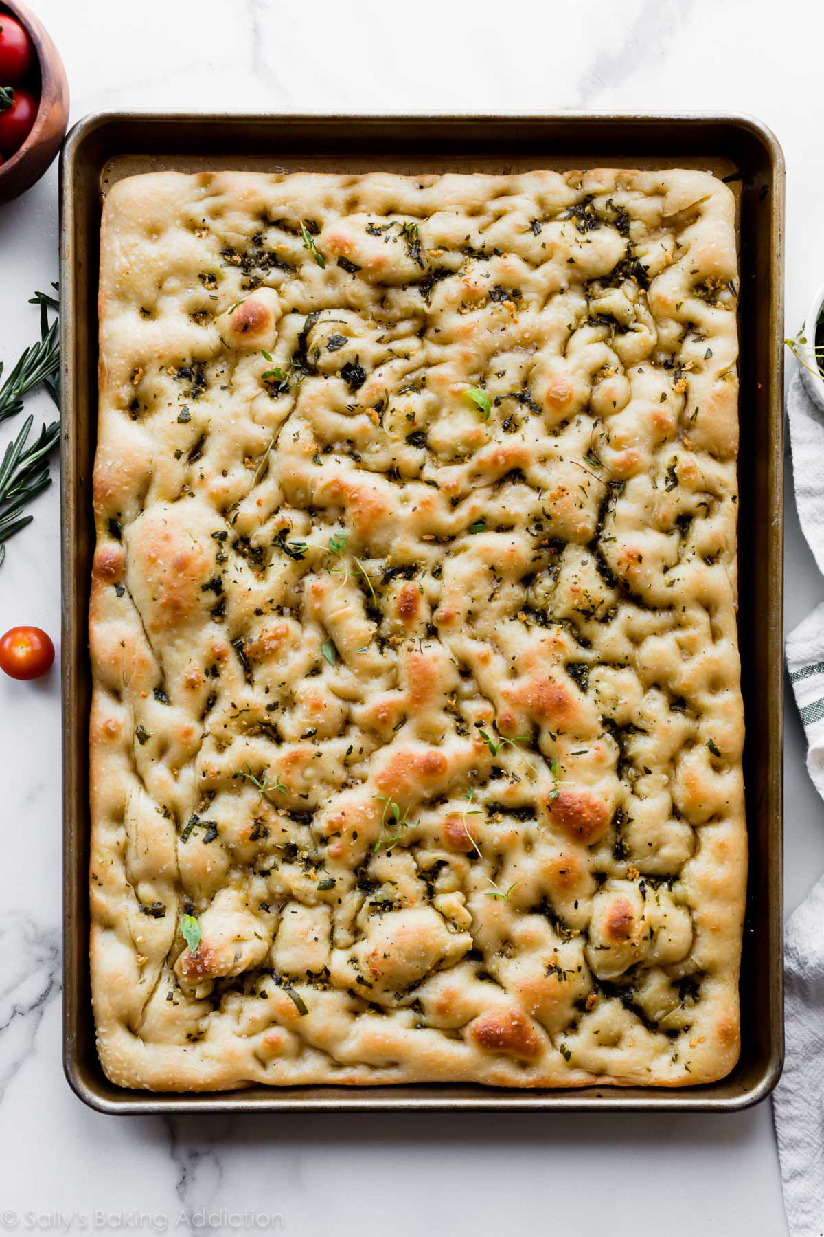 Garlic rosemary herb focaccia bread on baking sheet